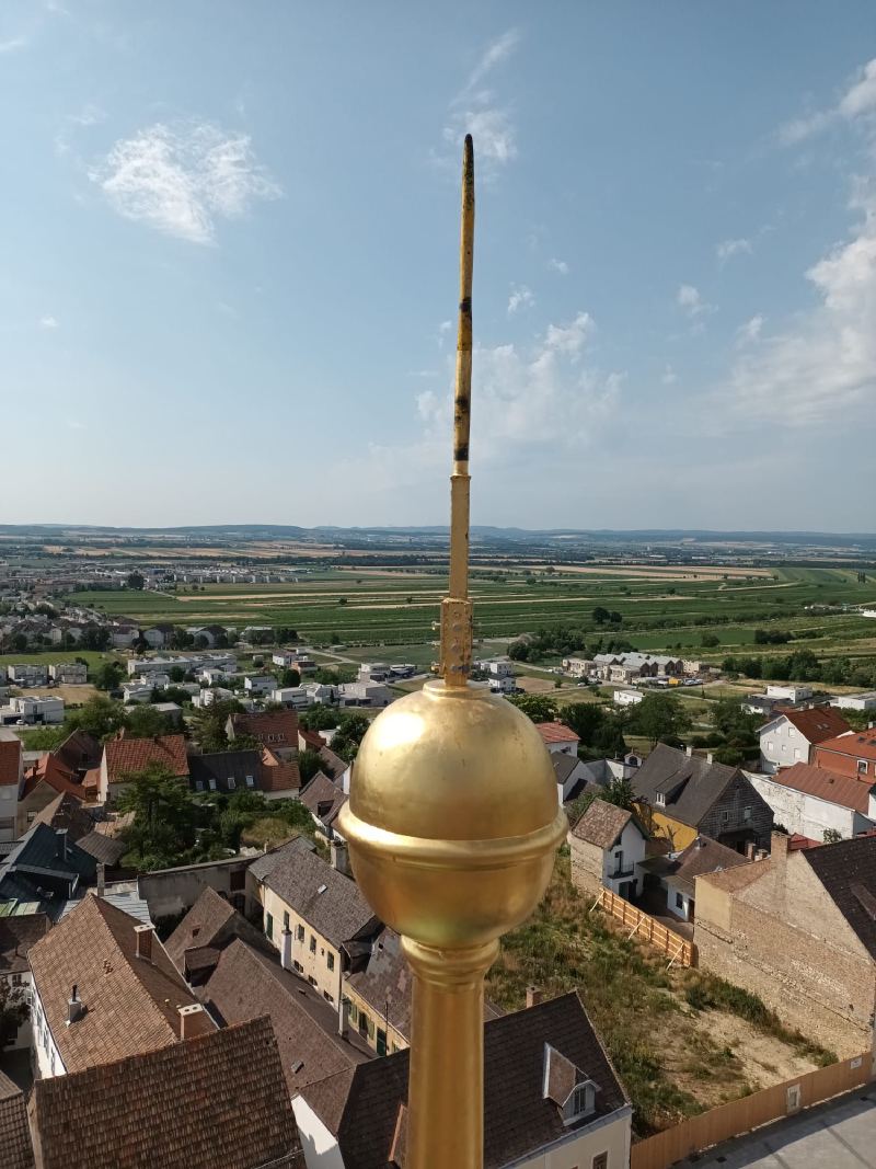Die neu vergoldete Turmkugel mit Turmspitze über den Dächern von Eisenstadt