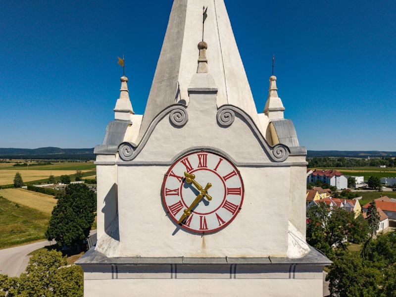 Kirchturm Oslip mit verblechten Gesimsen rund um die Turmuhr