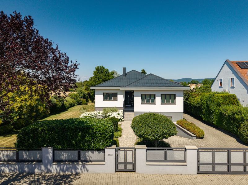 Gartenansicht des Einfamilienhauses mit anthrazitfarbenem PREFA-Dach